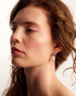 Woman wearing elegant pearl drop earrings