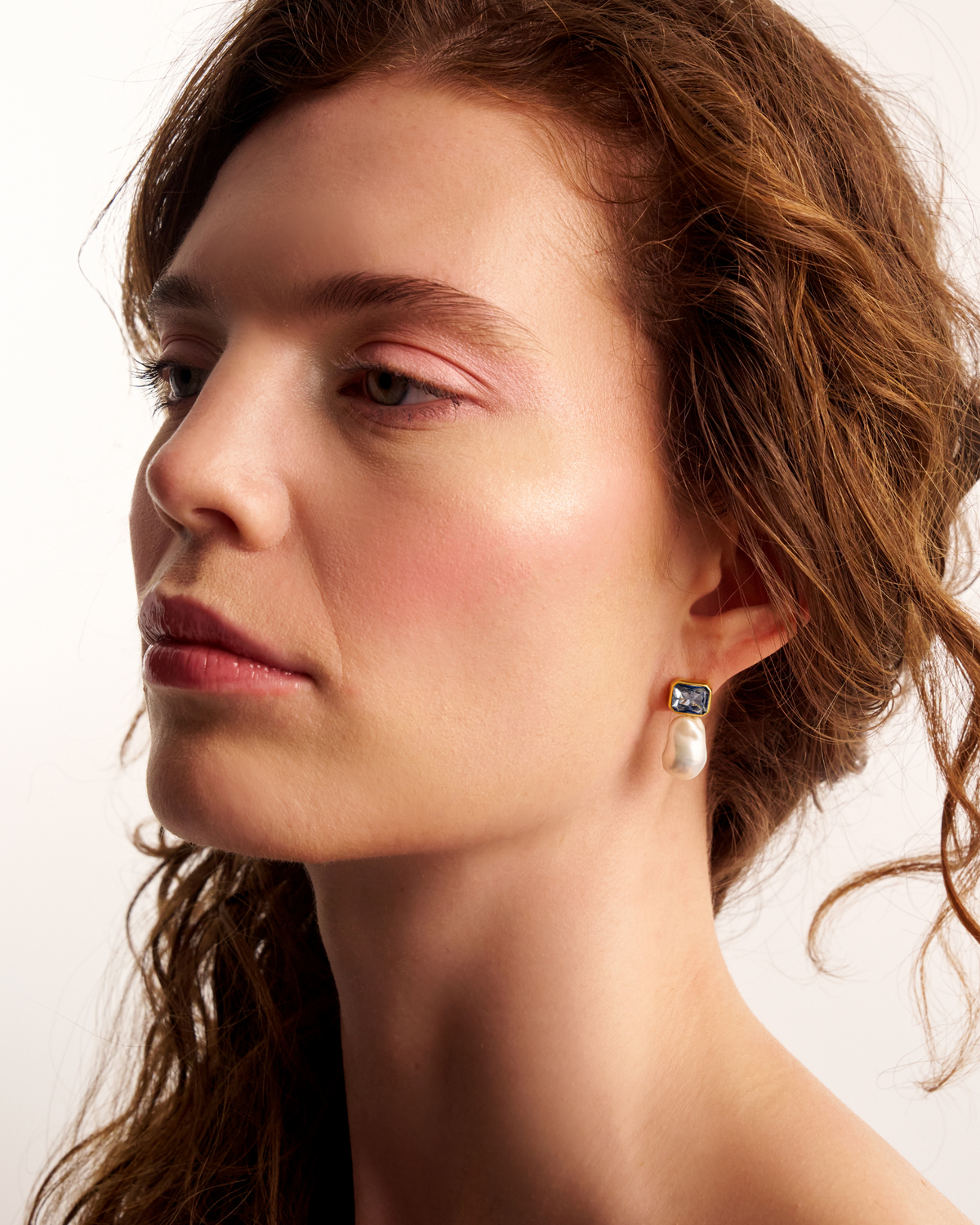 Woman wearing elegant pearl drop earrings