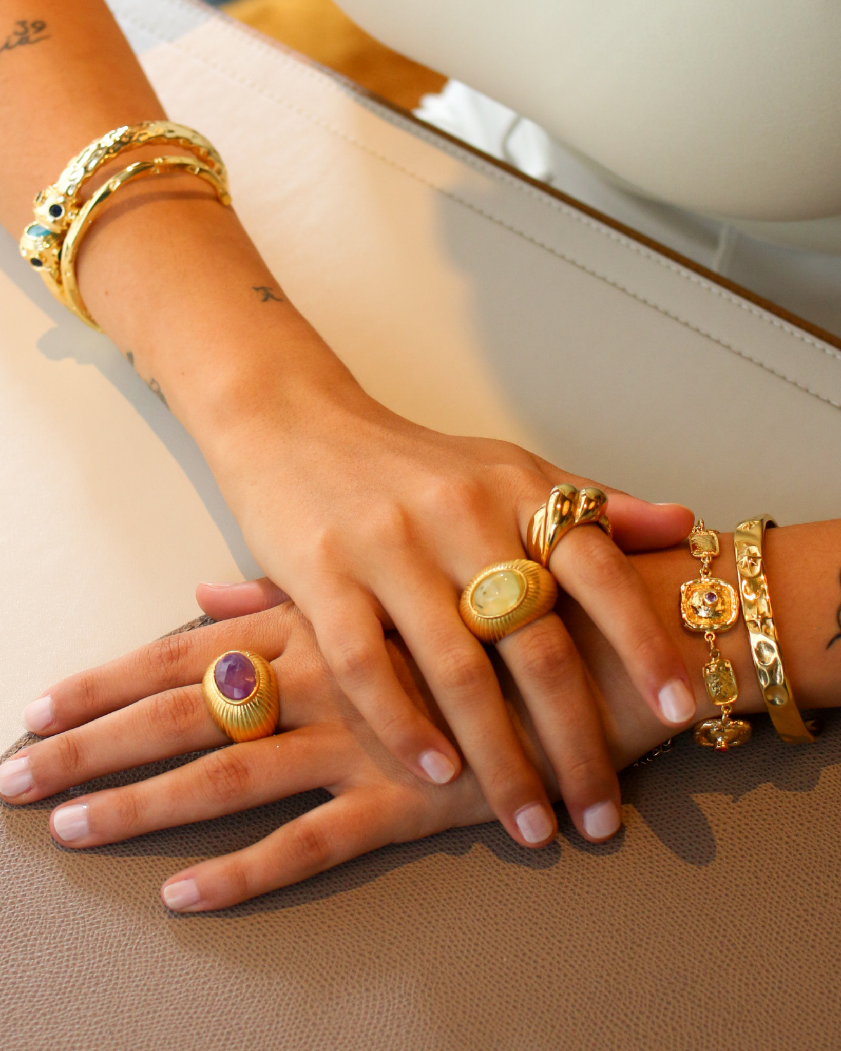 Gold amethyst ring worn with layered jewelry