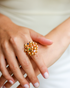 Gold gemstone bouquet ring worn on hand