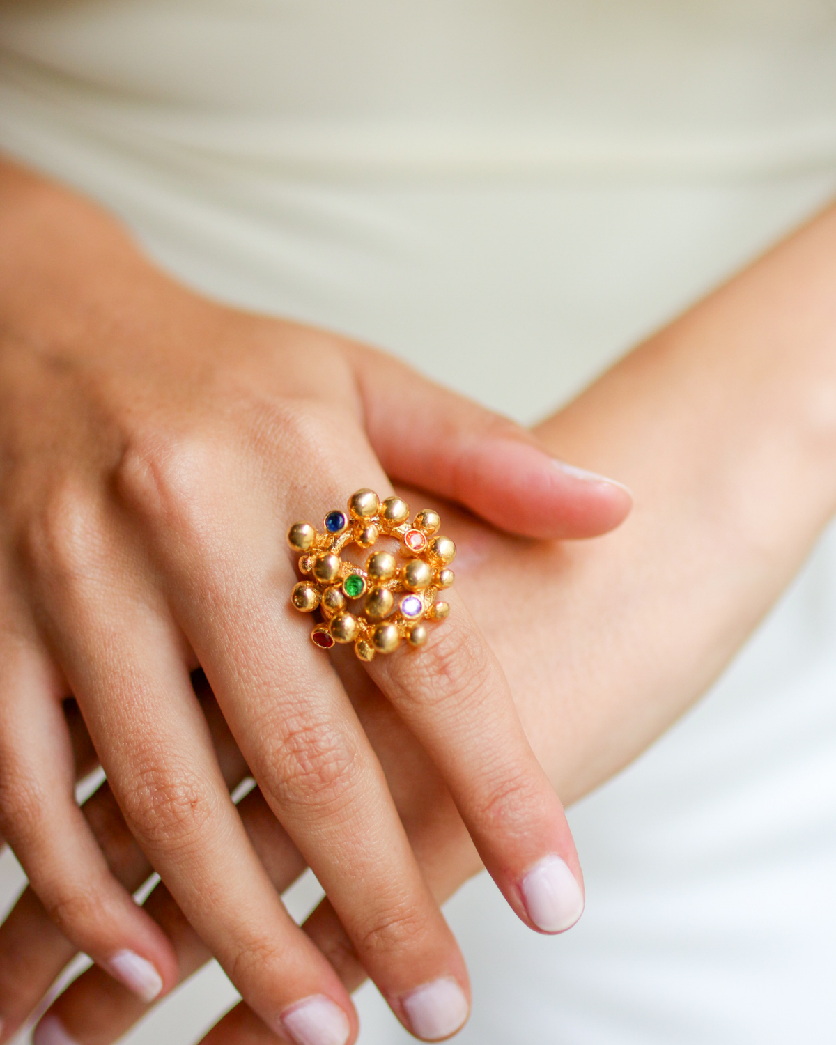 Gold gemstone bouquet ring worn on hand