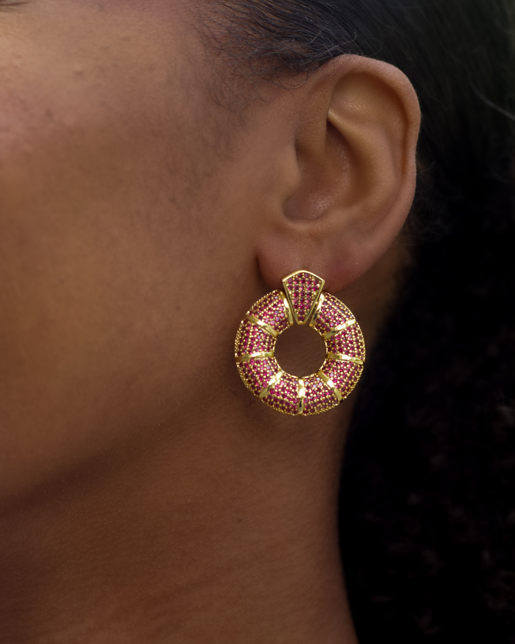 Model wearing pink donut hoop earrings