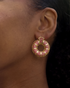 Model wearing pink donut hoop earrings