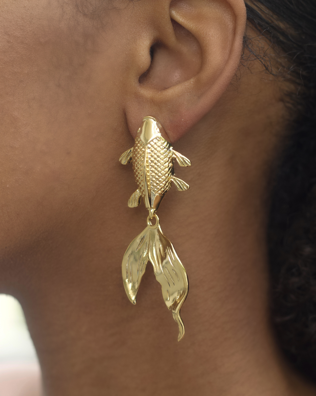 Close-up of koi fish earrings with textured details