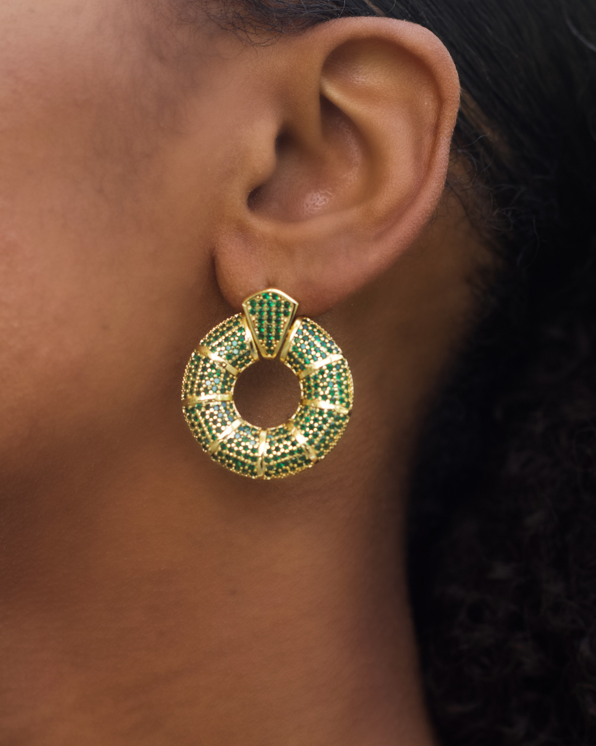 Model wearing green donut hoop earrings