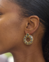 Model wearing blue donut hoop earrings