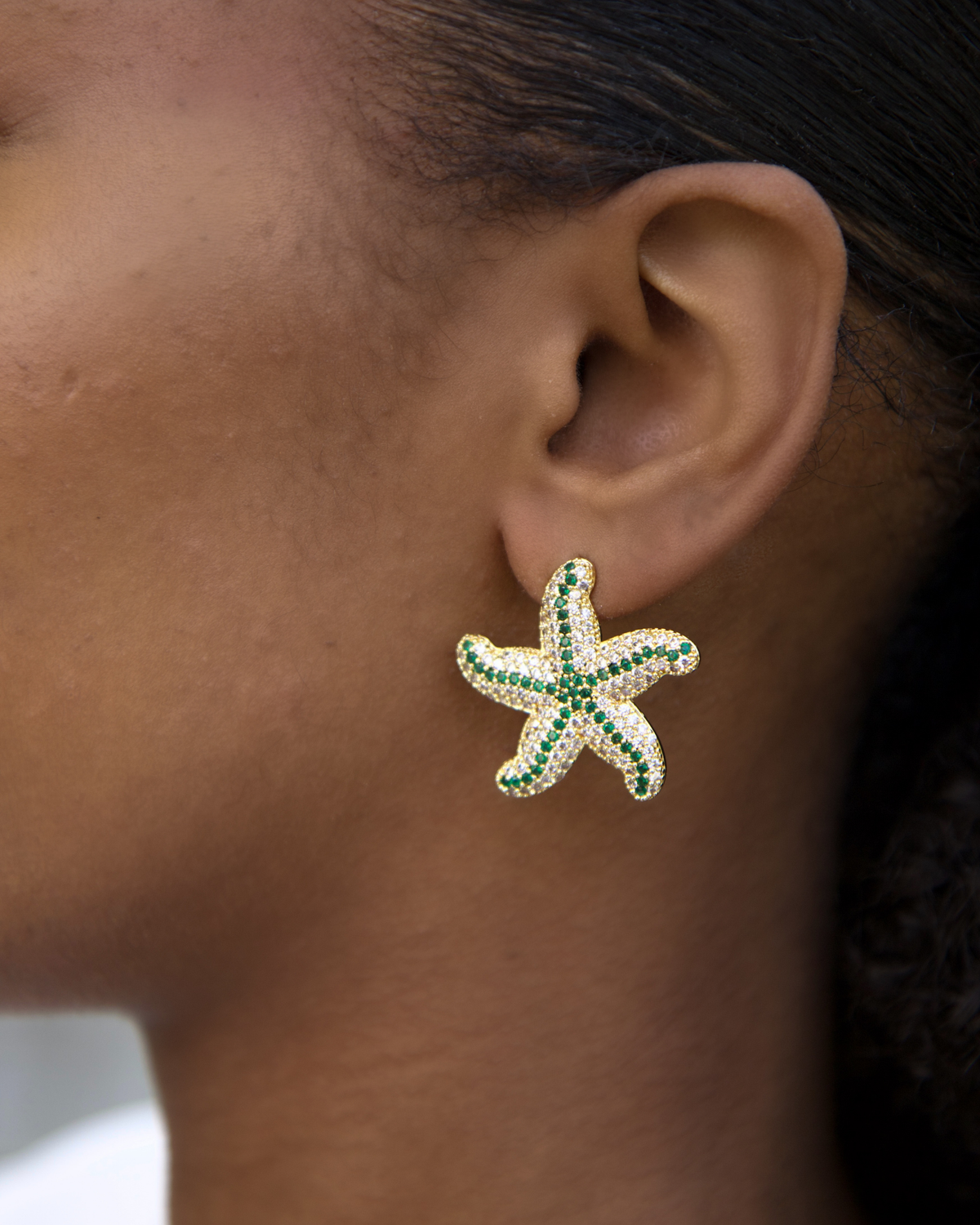 Model wearing green starfish earrings