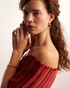 Woman wearing gold and green gemstone earrings