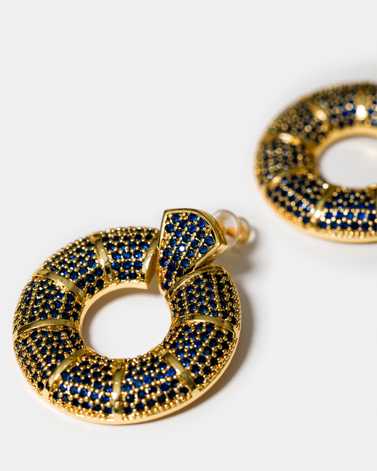 Close-up of blue zircon donut hoop earrings