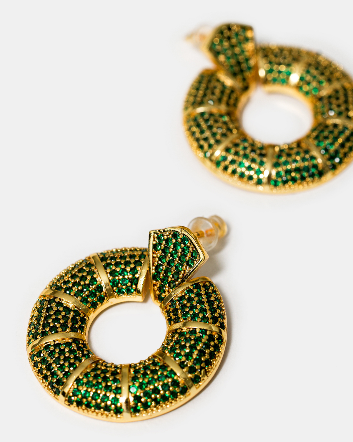 Close-up of green zircon donut hoop earrings