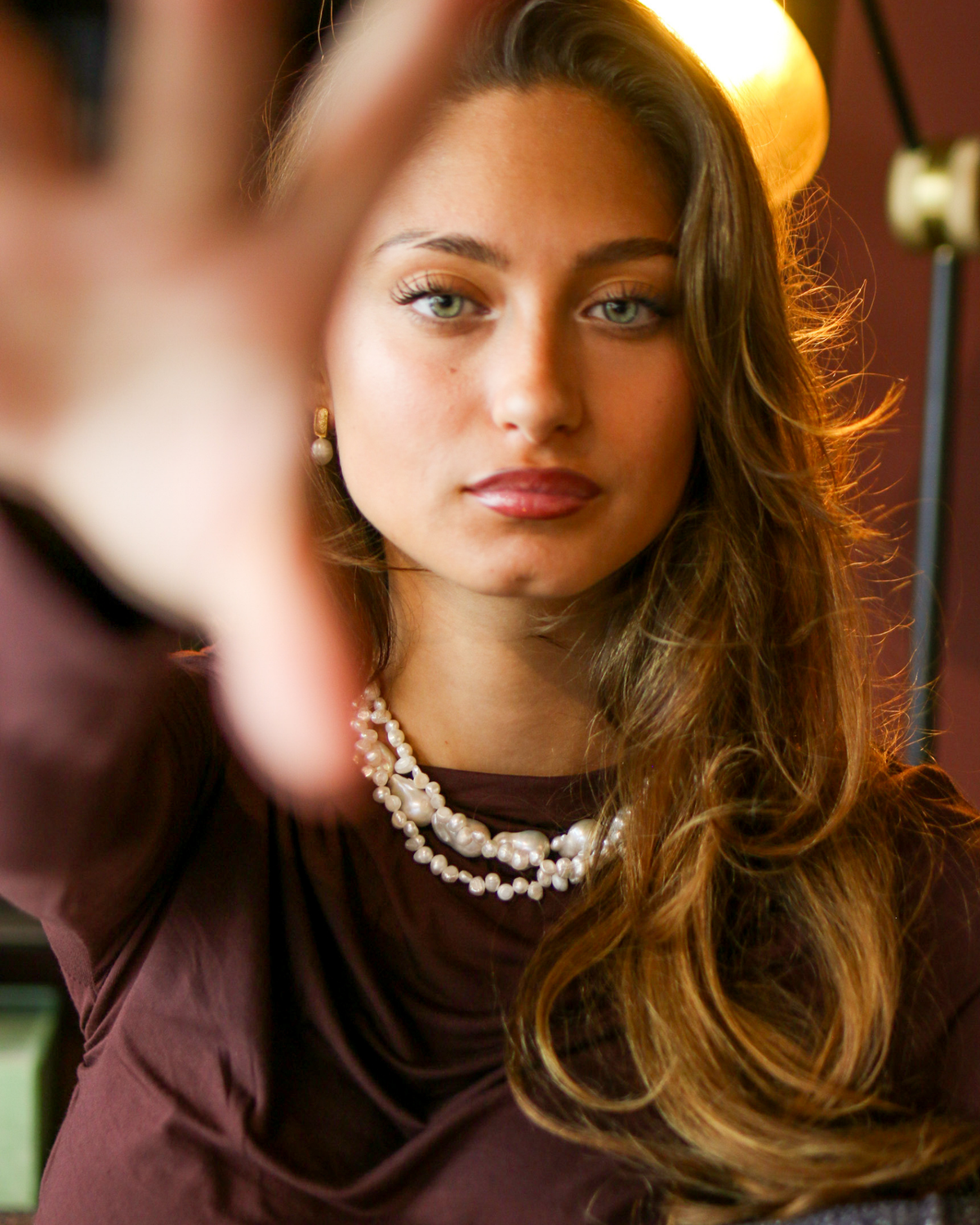 Woman wearing Baroque pearl gold stud earrings