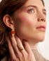 Woman wearing gold open gemstone ring