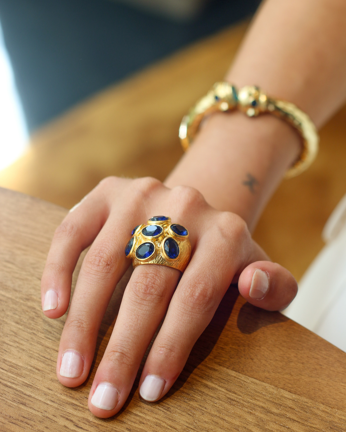 Gold sapphire cocktail ring worn on hand