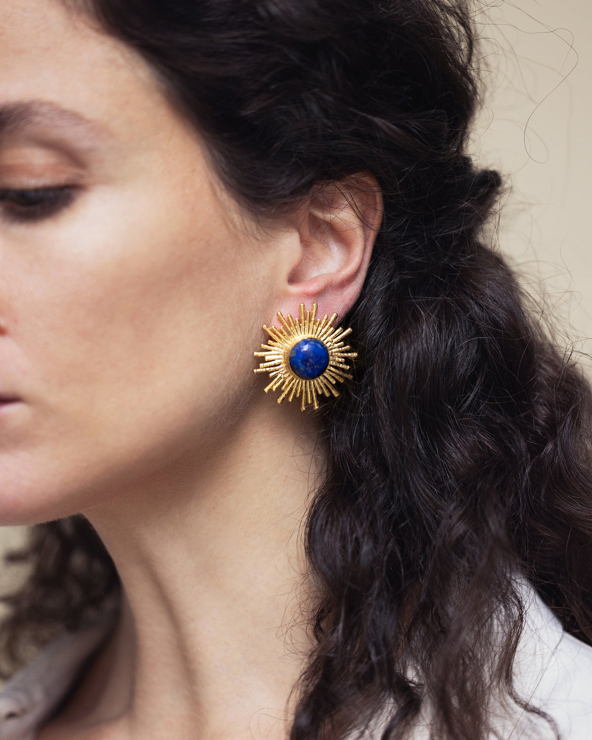Woman wearing Celestial Radiance lapis lazuli earrings with a sophisticated celestial style