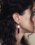 Woman wearing ruby and baroque pearl drop earrings in an elegant evening style