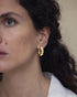 Woman wearing Kaleidoscope gold hoop earrings