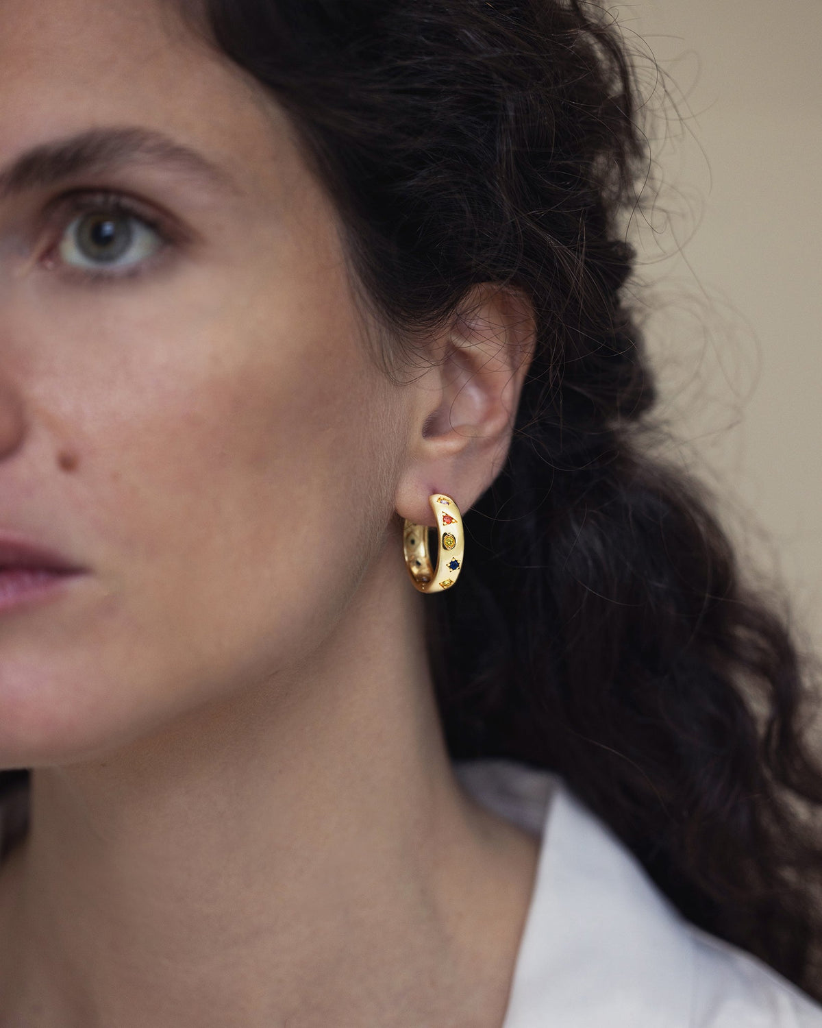 Woman wearing Kaleidoscope gold hoop earrings