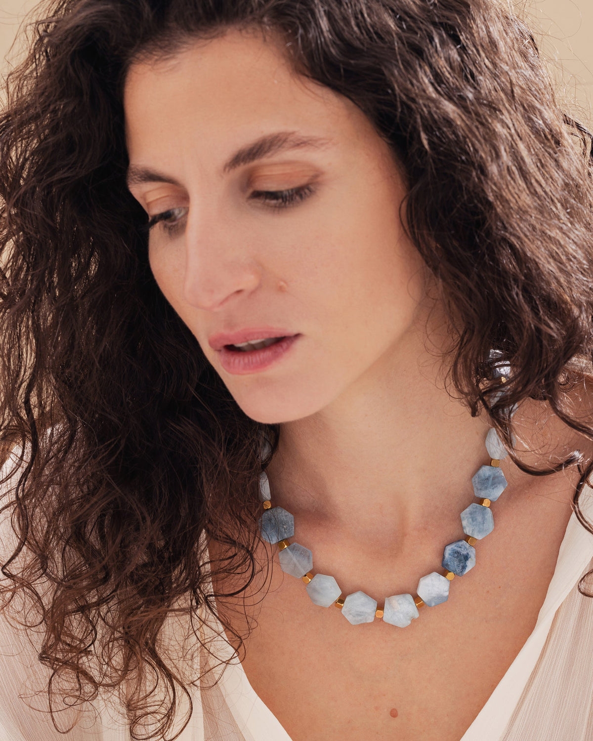 Close-up detail of hexagonal aquamarine beads and gold-plated accents