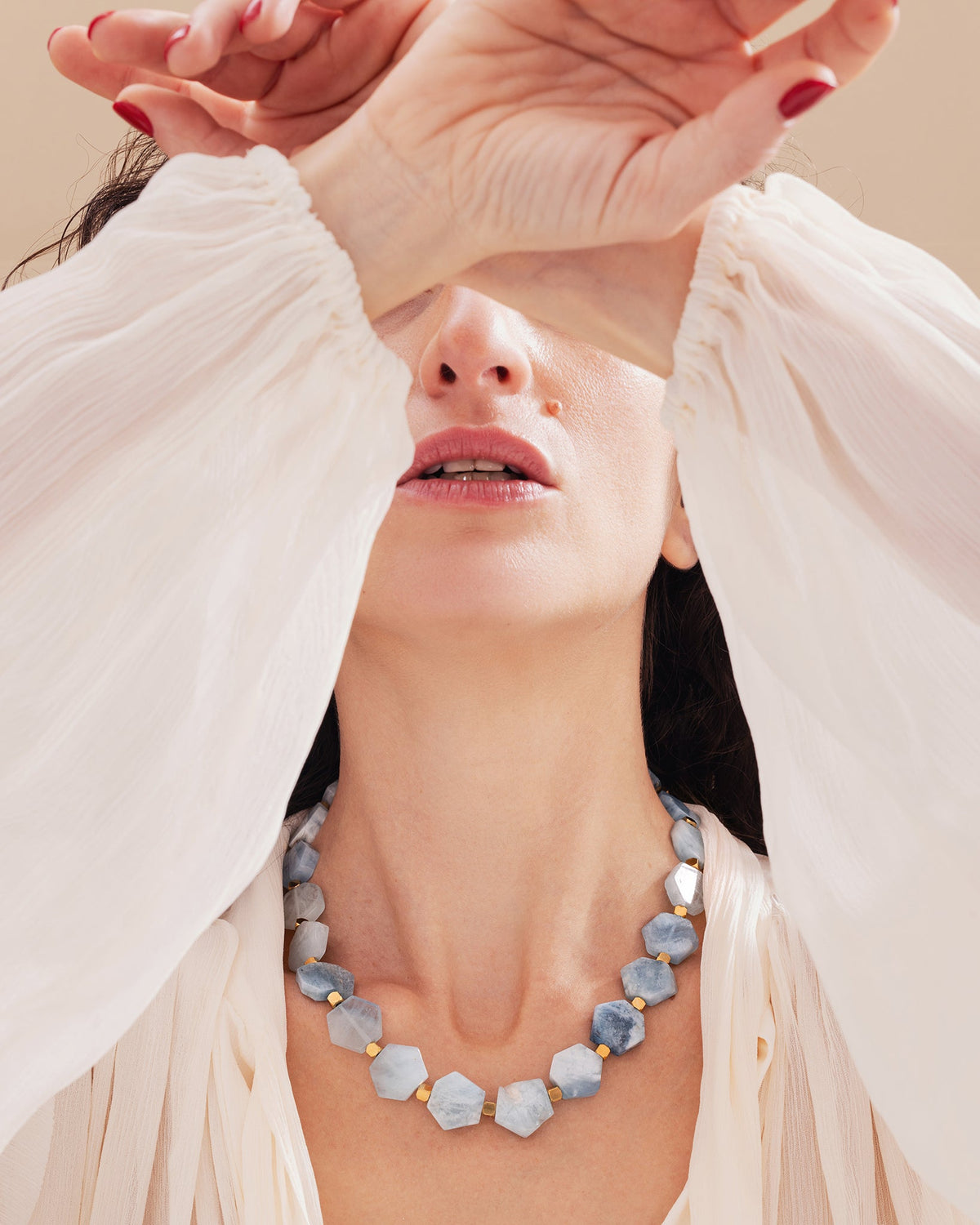 Woman wearing a calming aquamarine gemstone necklace in a natural style