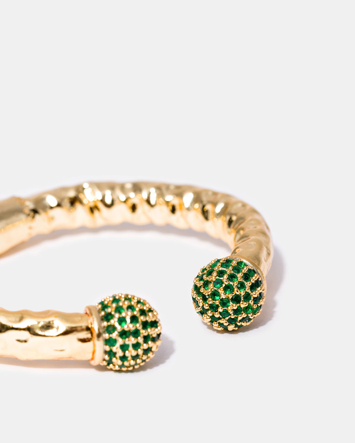 Close-up of green zircon stone accents on gold-plated bangle