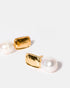 Close-up of baroque pearl and gold stud earrings