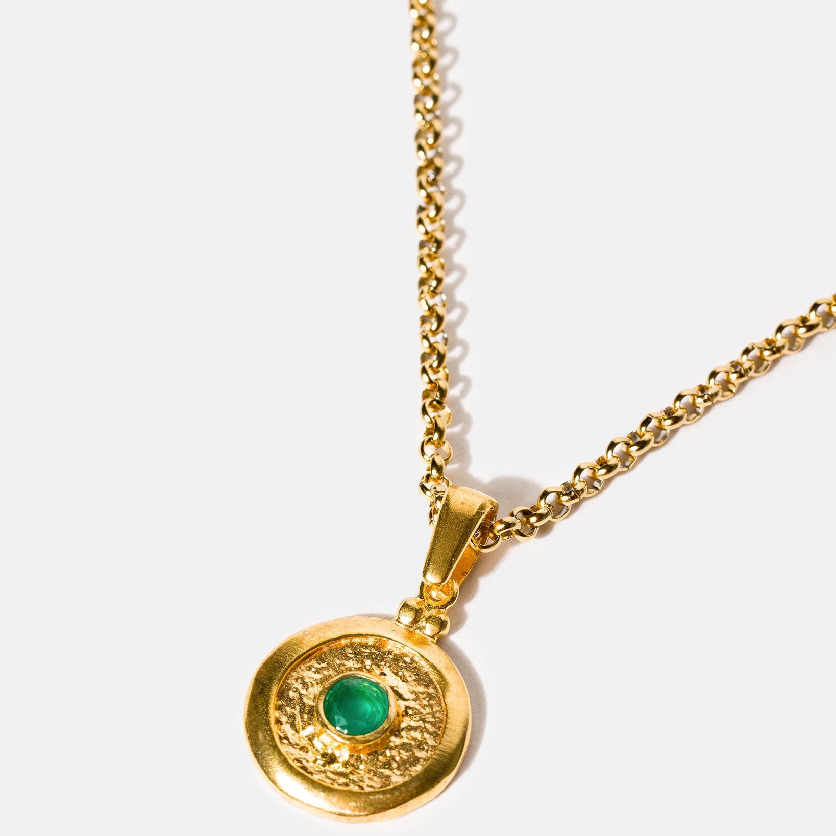 Gold medallion pendant necklace with emerald green stone
