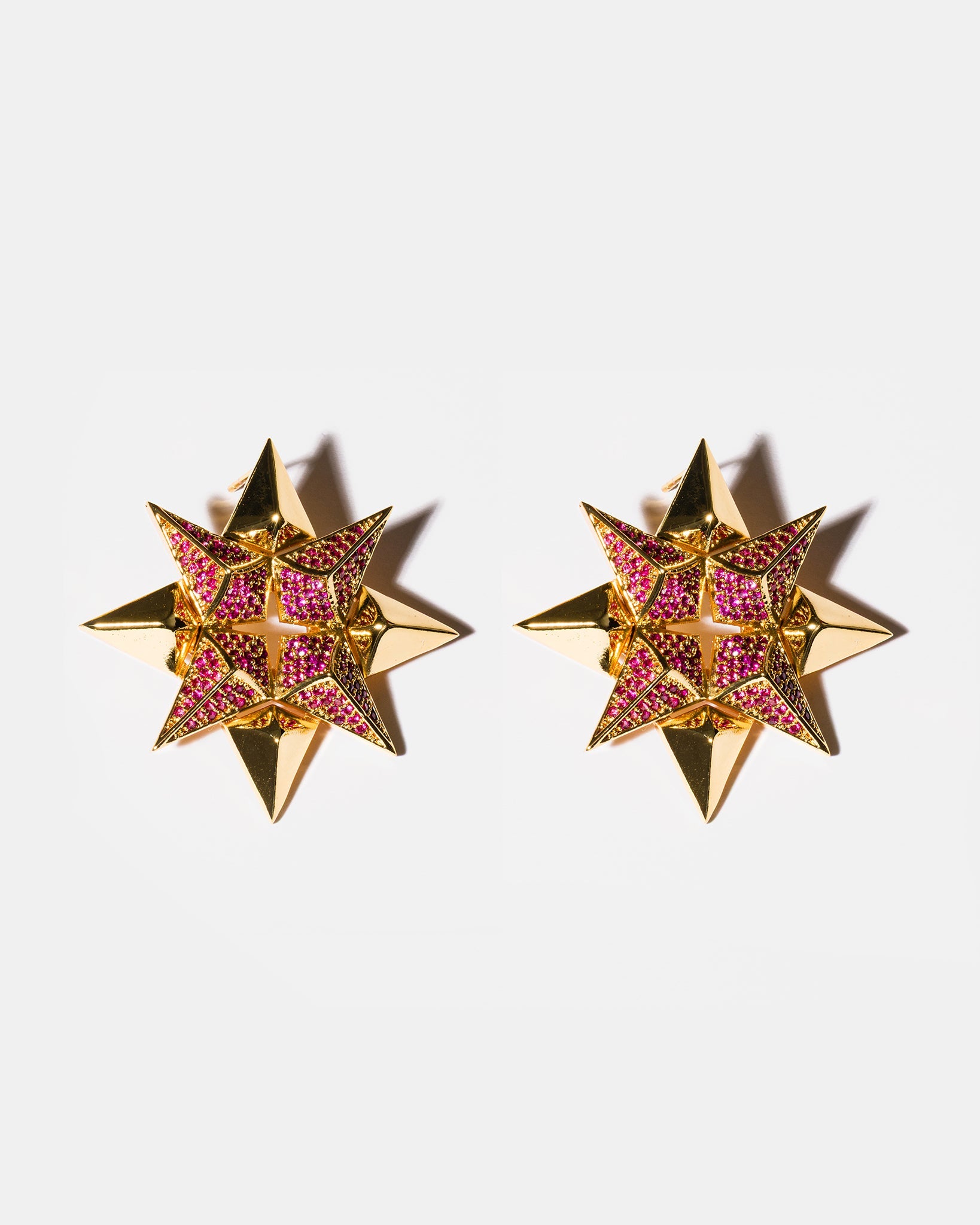 Ruby starburst earrings flatlay