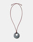 Black rhodonite donut pendant necklace on adjustable burgundy cord
