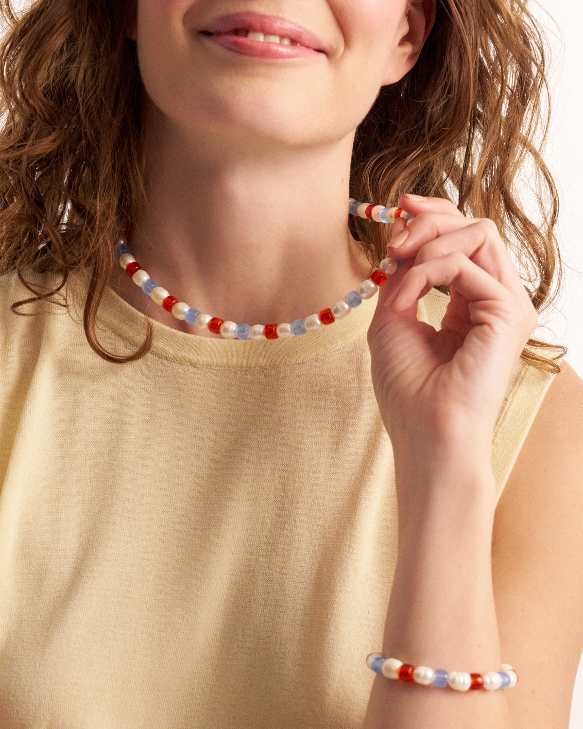 Woman holding colorful pearl necklace