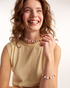 Smiling woman styling colorful pearl necklace