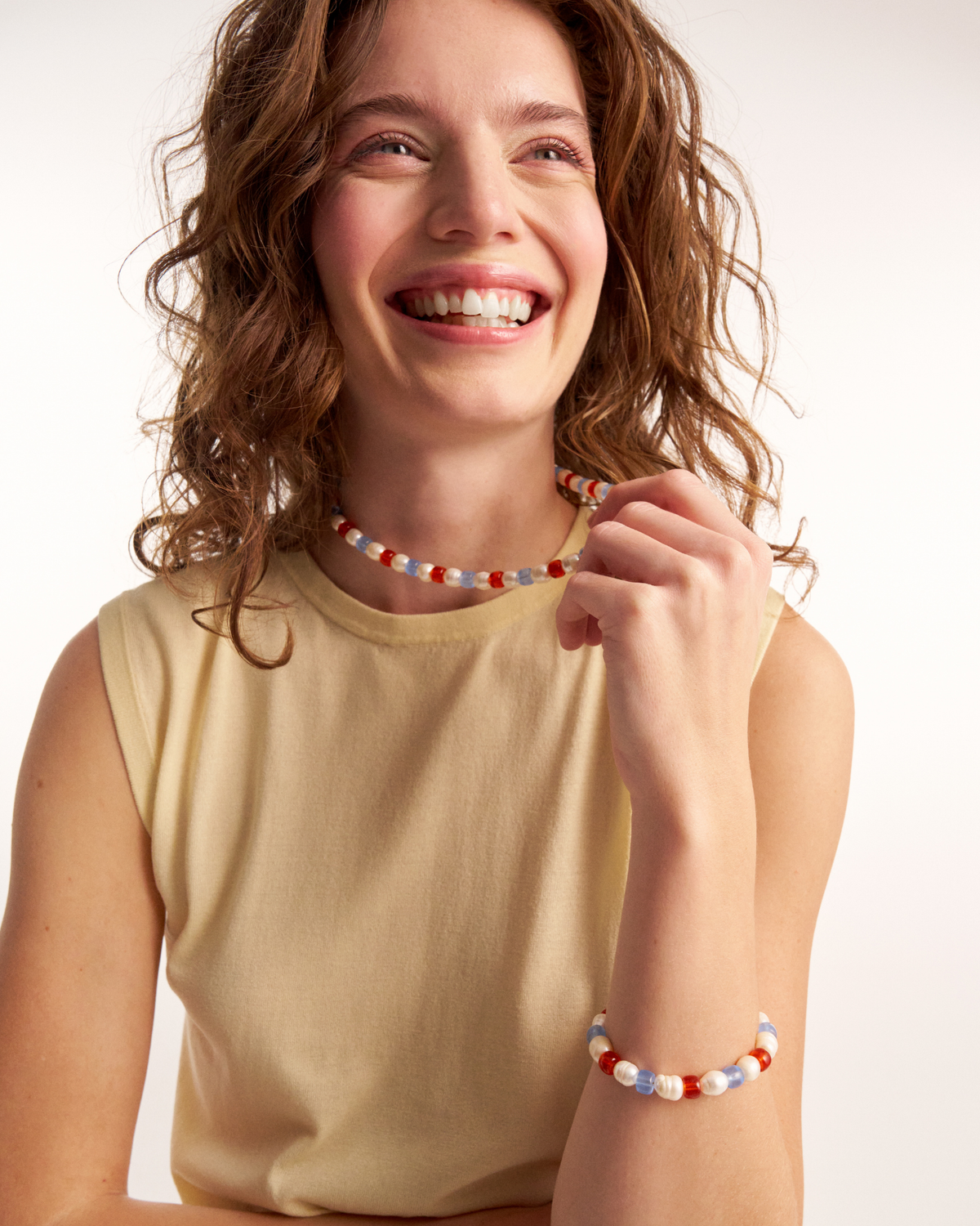Smiling woman styling colorful pearl necklace
