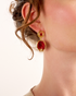 Side profile of woman wearing pomegranate-inspired red gemstone earrings
