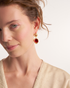 Woman wearing pomegranate jade earrings in a natural lifestyle portrait