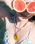 Woman wearing golden agate donut pendant necklace in summer sunlight