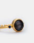 Close-up detail of black cat eye ring featuring a sleek gold-plated setting