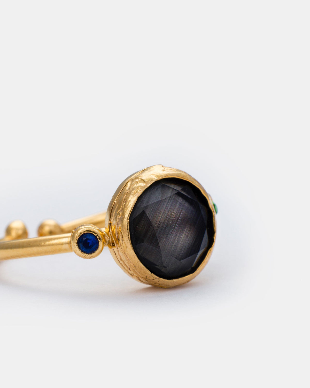 Close-up detail of black cat eye ring featuring a sleek gold-plated setting