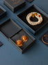 Styled flat lay of citrine sunburst earrings with luxury jewelry presentation