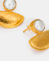Close-up of pearl and textured gold crescent earrings