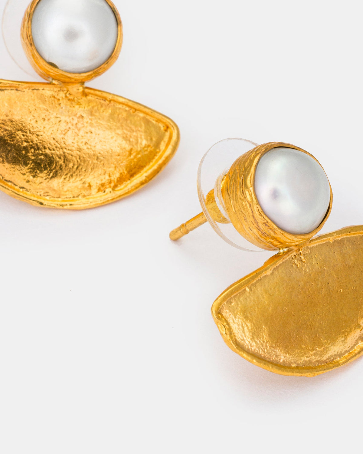 Close-up of pearl and textured gold crescent earrings