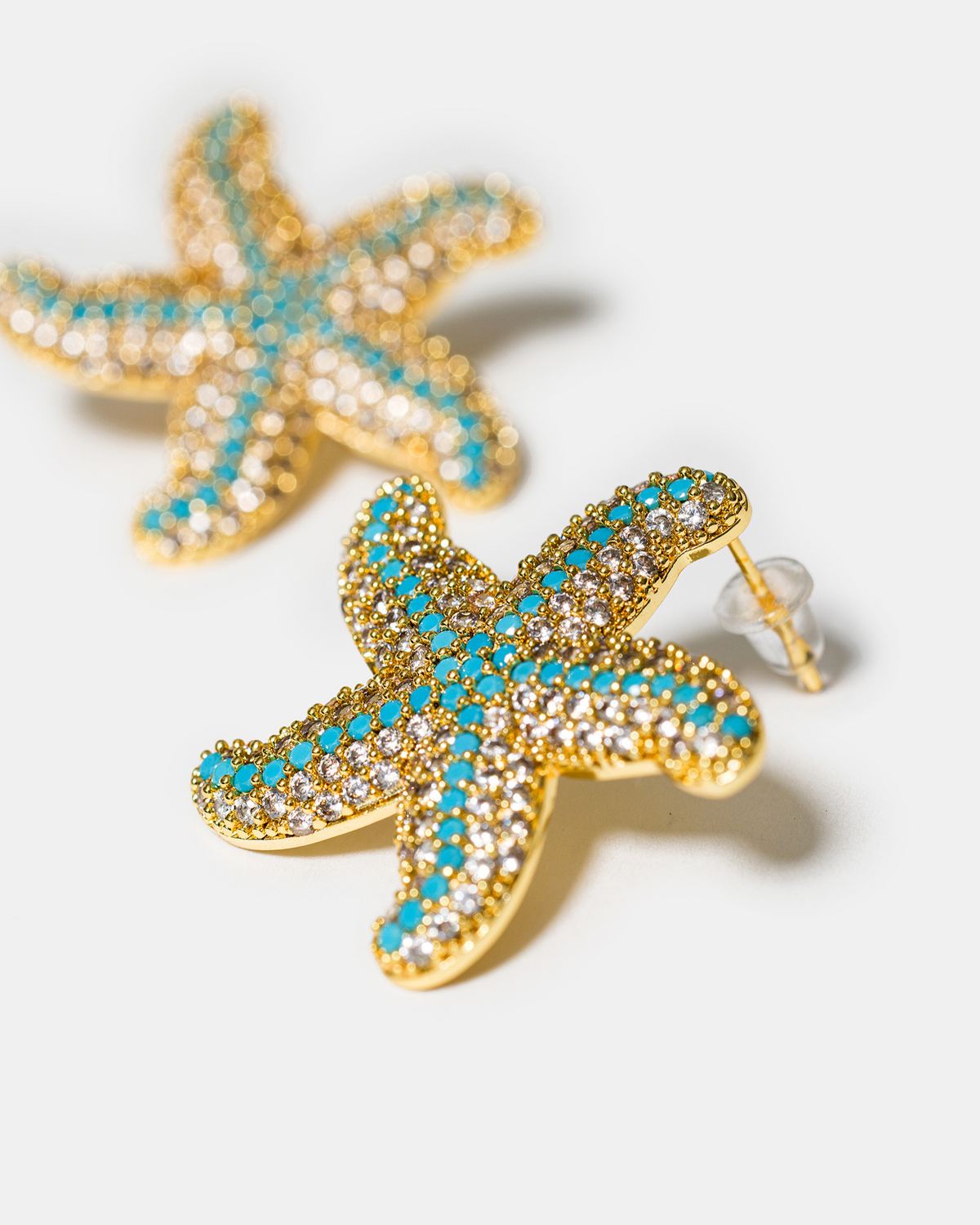 Close-up of turquoise zircon starfish earrings